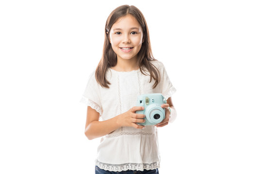 Child the girl with the camera in hands on the white isolated background