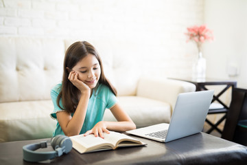 Focused school girl sitting on floor and studying