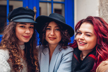 Three beautiful women taking selfie on city street. Friends hanging and having fun