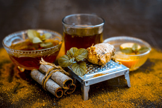 Close up of Ayurvedic home remedy for common cold: Fresh organic ginger ( grated) , warm water, cinnamon stick, honey, and lemon juice.