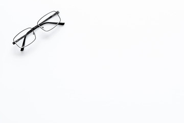 One glasses with transparent lenses on white background top view copy space