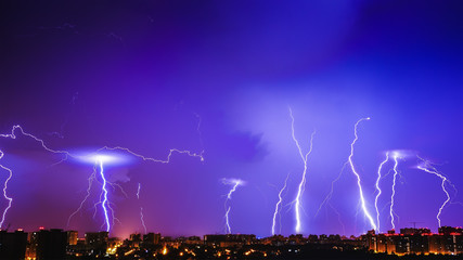 Fototapeta na wymiar Thunderstorms vivid blue sky and many lightnings above night city