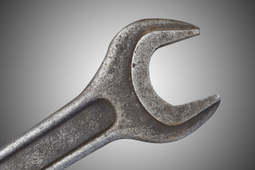 Old spanner on grey background