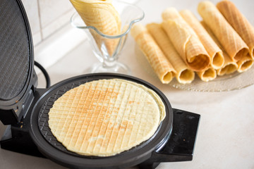 Waffle iron in the kitchen. Preparing homemade waffles, pouring a dough