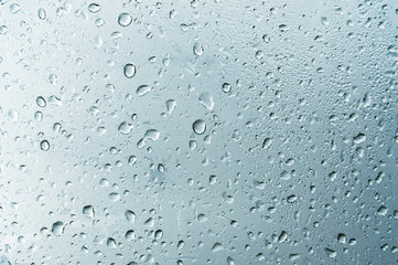 Textured background of window panes with a cloudy background. Natural pattern from a drop of rain...
