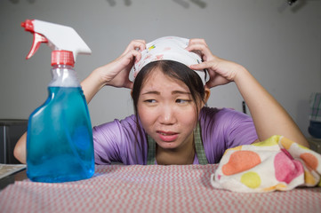 young pretty overworked and stressed Asian Korean service maid woman working domestic cleaning and washing with spray bottle angry and upset