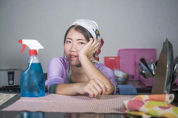 young pretty overworked and stressed Asian Korean service maid woman working domestic cleaning and washing with spray bottle angry and upset