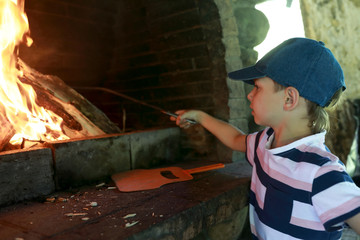 Child burning firewood for barbecue