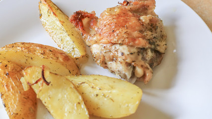 Fried potatoes with chicken with golden crust on a white plate