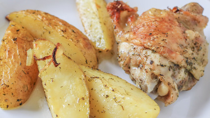 Fried potatoes with chicken with golden crust on a white plate