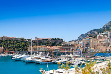 Many motor yachts docked in Fontvielle harbour on a sunny day, Monaco.