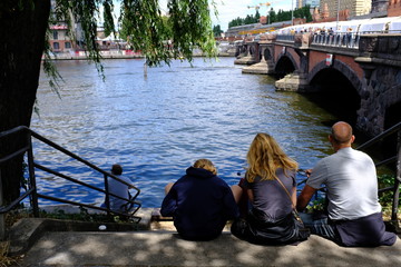 A family at the spree-river in Kreuzberg-Berlin on a warm and sunny day