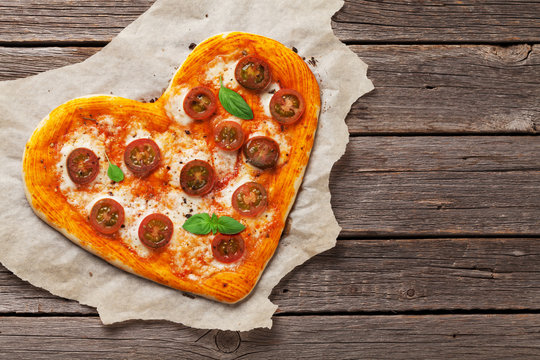 Heart shaped pizza with tomatoes and mozzarella