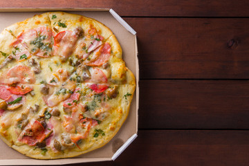 Italian pizza on wooden boards, pizza with bacon, dried tomatoes and Parmesan cheese, Italian cuisine, appetizing dish with meat and cheese, copy space