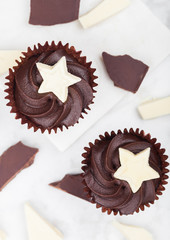 Dark chocolate cupcakes with white star on marble