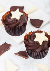 Dark chocolate cupcakes with white star on marble