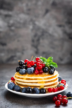 Pancakes with fresh berries. Pancakes with raspberry, blueberry, redcurrant, black currant and honey
