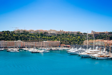 Fototapeta na wymiar Many motor yachts docked in Fontvielle harbour on a sunny day, Monaco.