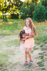 Two Happy little girls having fun and embracing  at sunny summer day