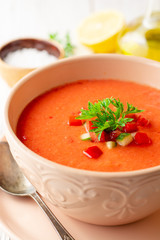 Gazpacho soup in bowl on white wooden background. Traditional spanish dish.