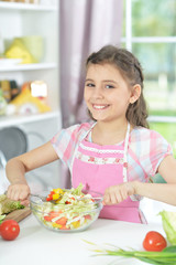 Cute girl preparing delicious fresh salad