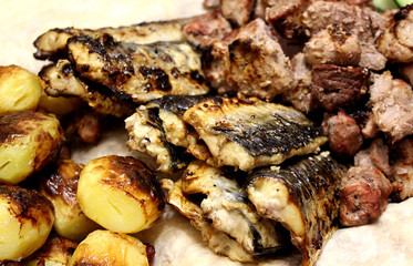 fried fish on the grill potatoes and meat