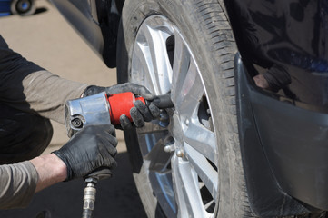 Fototapeta premium mechanic changes the wheel on a modern car