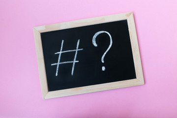 Blackboard with a chalk hashtag and a question mark written on it. Social media promotion concept.