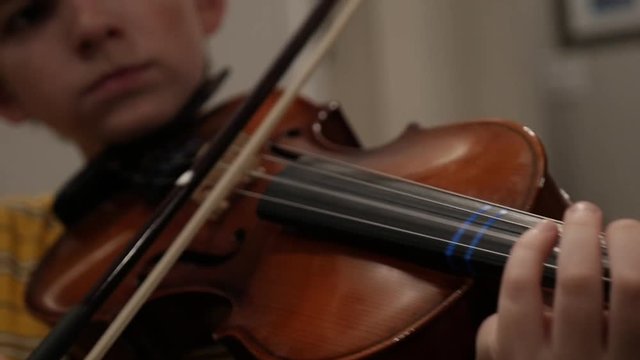 Young 10 - 12 year old boy playing violin in slow motion
