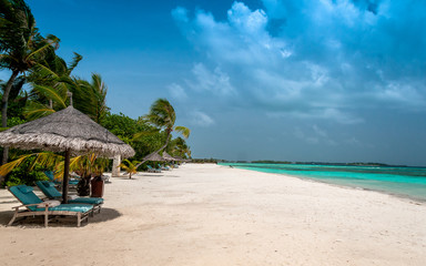 Tropical beach with palms on the background of the island. Perfect escape. Honeymoon 