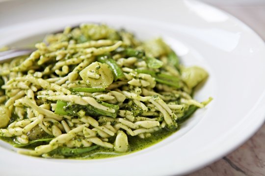 Traditional handmade Ligurian Pasta Trofie with fresh Pesto alla Genovese sauce . Natural light.