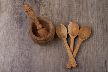 three wooden spoons lie next to a wooden stupa on a wooden table