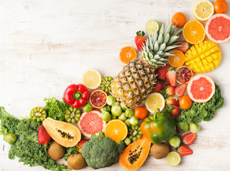 Fruits and vegetables rich in vitamin C arranged diagonally oranges mango grapefruit kiwi kale pepper pineapple lemon sprouts papaya broccoli, on white table, top view, copy space, selective focus