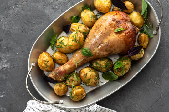 Roast turkey drumsticks with fried potatoes, basil. Holiday dinner. Copy space.