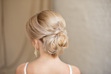 Rear view of female hairstyle middle bun with blond hair.