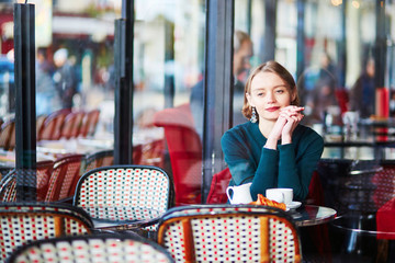 Young elegant woman drinking coffee in cafe in Paris, France
