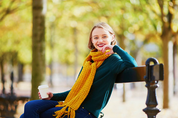 Happy young girl in yellow scarf walking in autumn park