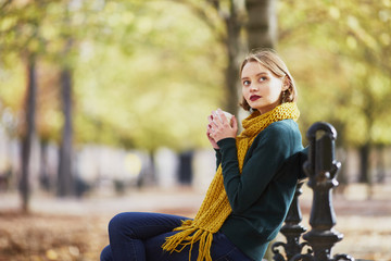 Happy young girl in yellow scarf walking in autumn park