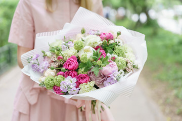 Young girl holding a beautiful summer bouquet. flower arrangement with peonies. The concept of a flower shop. Content for the catalog