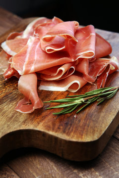 Italian prosciutto crudo or jamon with rosemary. Raw ham.