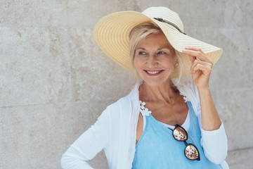 Smiling mature blonde woman wearing summer hat