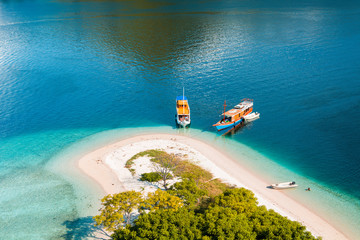 Part of the coast from the top of 'Kelor Island' in an afternoon with turquoise sea and tourist boats, Komodo Island (Komodo National Park), Labuan Bajo, Flores, Indonesia