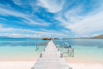 View of the wooden pier from the coast of Kanawa Island with turquoise sea and sand beach, Komodo Island (Komodo National Park), Labuan Bajo, Flores, Indonesia