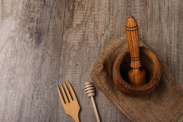 stupa and pestle on burlap on the village table. kitchenware. crush. fork and stick for honey. manual spice reclamation eco-friendly material. ecology. naturalness