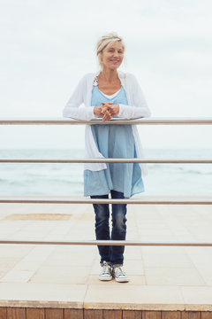 Trendy blond woman standing on a wooden pier