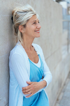 Smiling relaxed blond woman with folded arms
