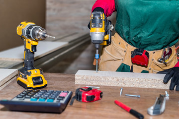 Obraz premium Carpenter with screwdriver constructing furniture in carpentry