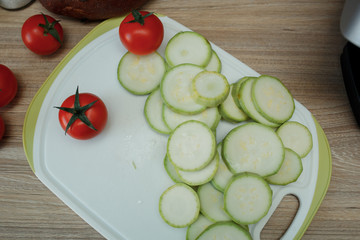 Products, tomatoes, zucchini, mushrooms clean on a table in a plate, top view