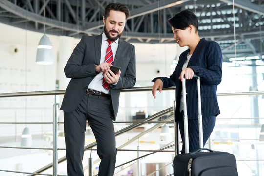 Business colleagues standing with luggage at the airport