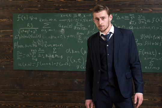Talented mathematician. Man formal wear classic suit looks smart, chalkboard with equations background. Genius solved mathematics problem. Teacher smart student intrested math physics exact sciences